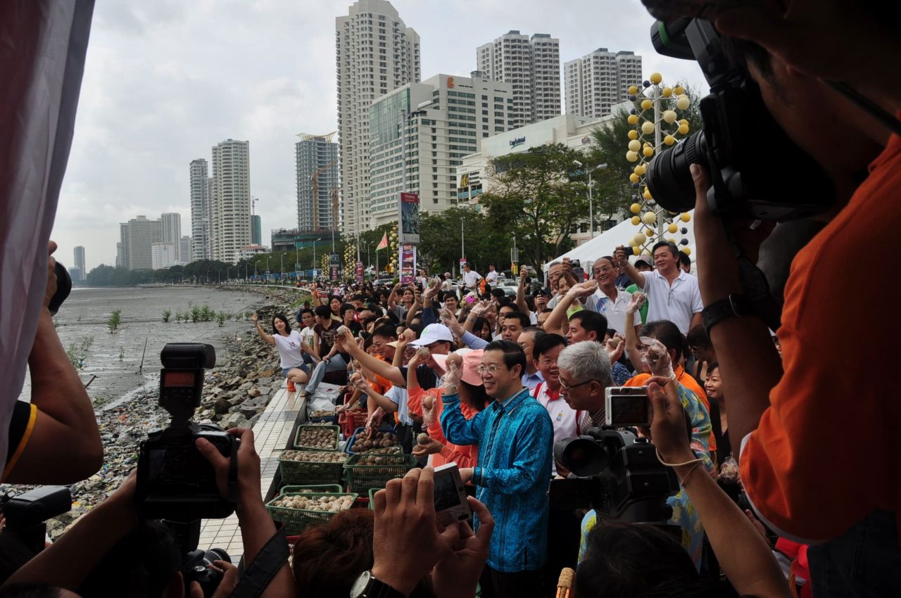 Chief Minister of Penang thowing EM Mudballs at Gurney Drive